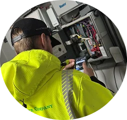 A man in a yellow jacket is holding a cell phone to his ear while standing outdoors.